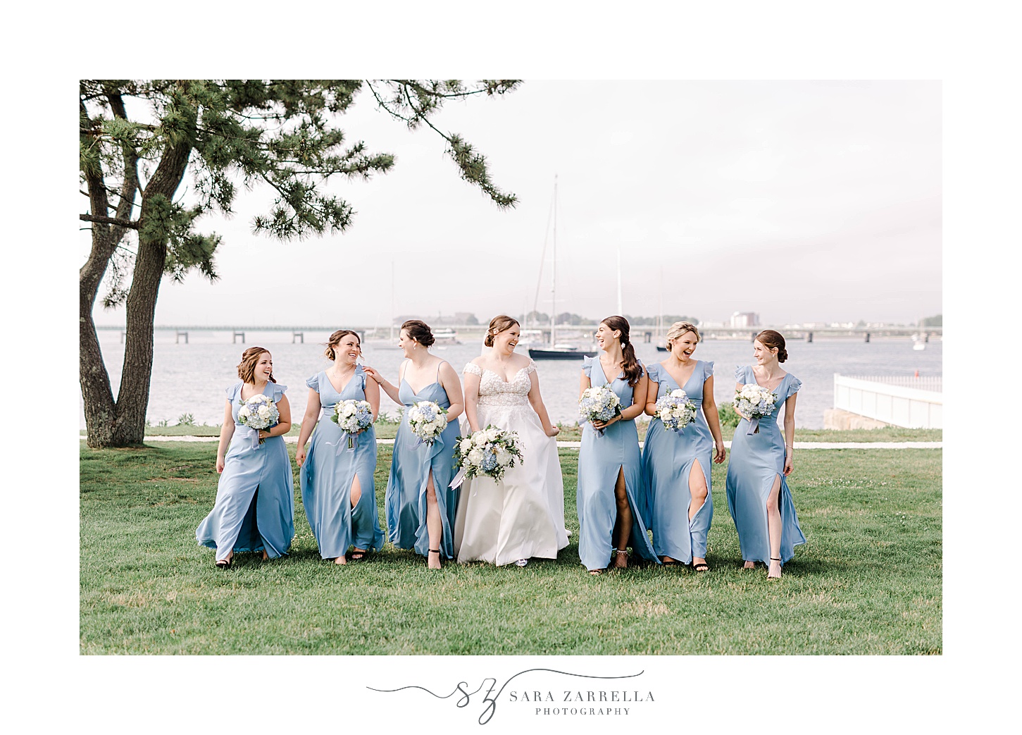 bride walks with bridesmaids in light blue gowns at Newport Harbor Island Resort