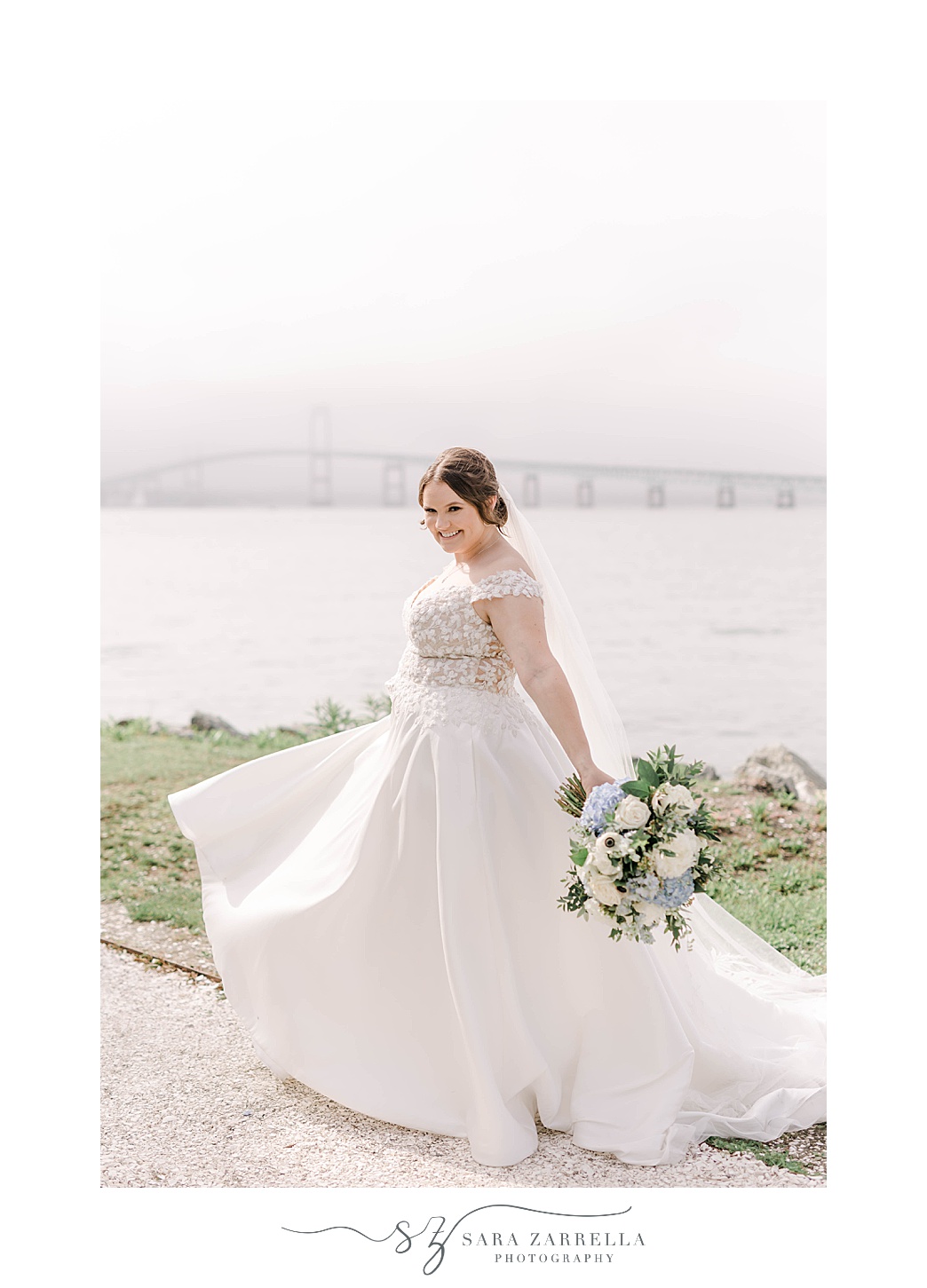 bride twirls wearing wedding dress in front of Bay in Newport RI