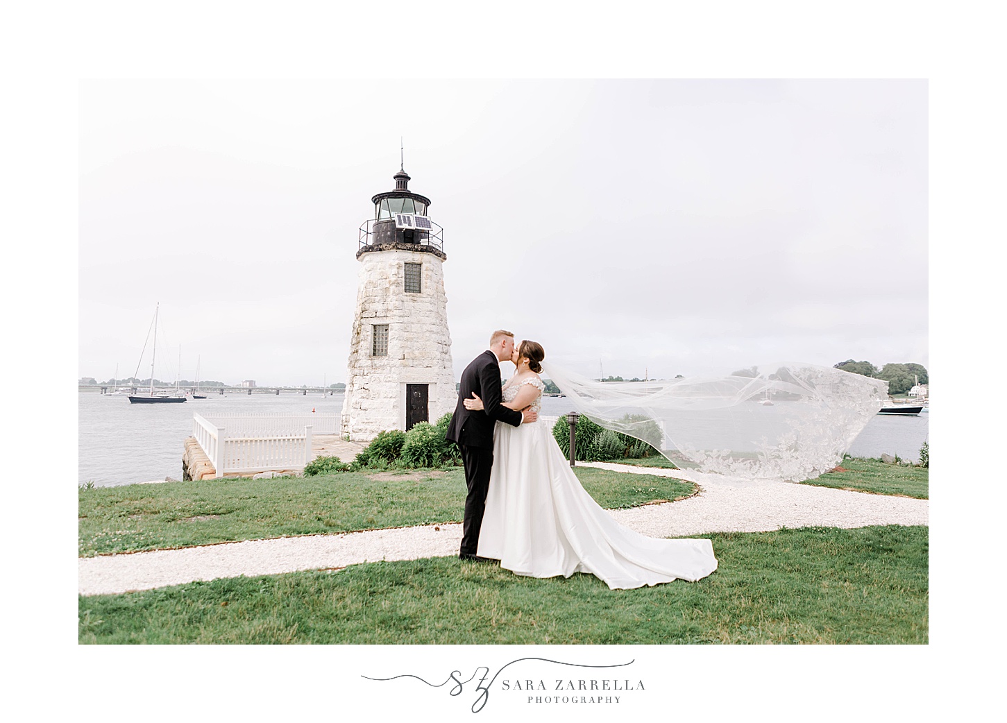 bride and groom kiss with veil floating behind them at Newport Harbor Island Resort