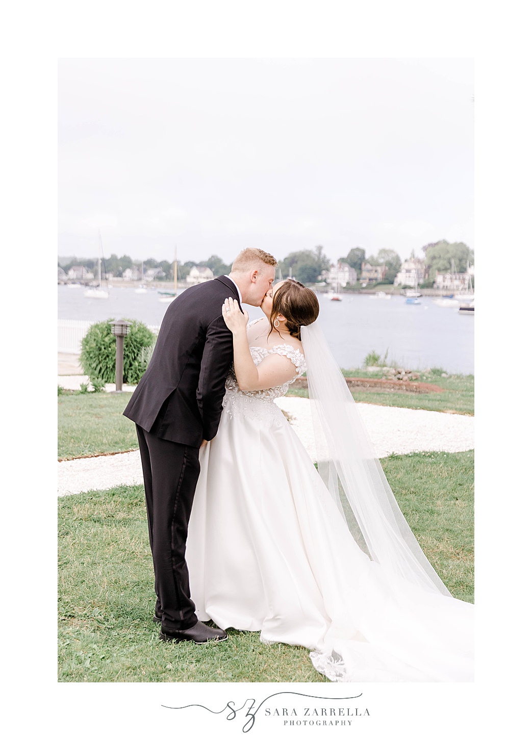 bride and groom kiss in front of Narragansett Bay 