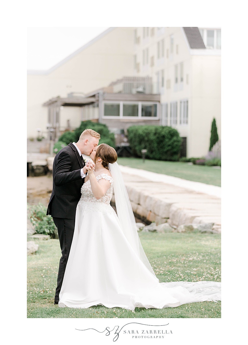 bride and groom kiss in front of Newport Harbor Island Resort
