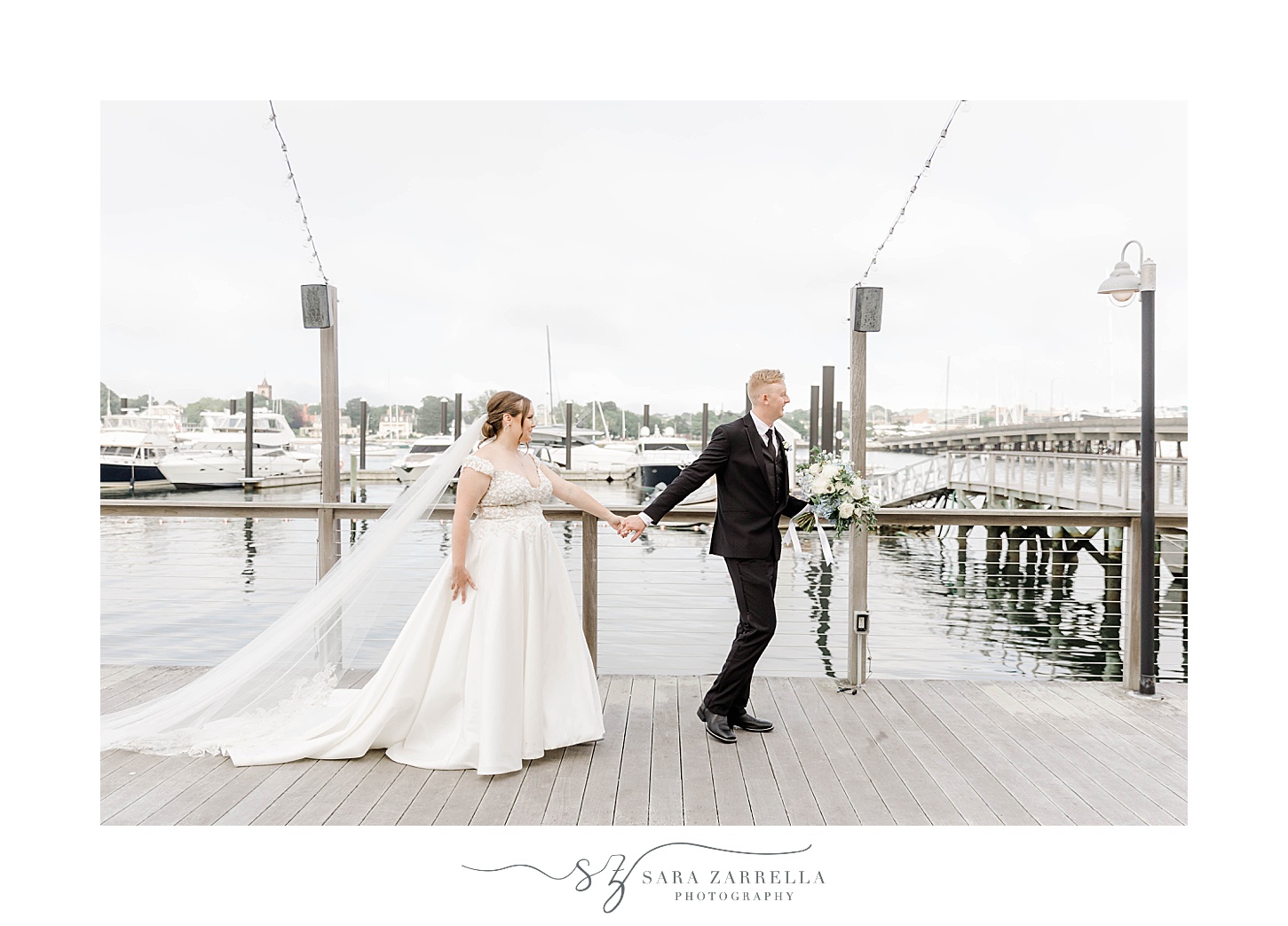 bride and groom walk along dock outside Newport Harbor Island Resort