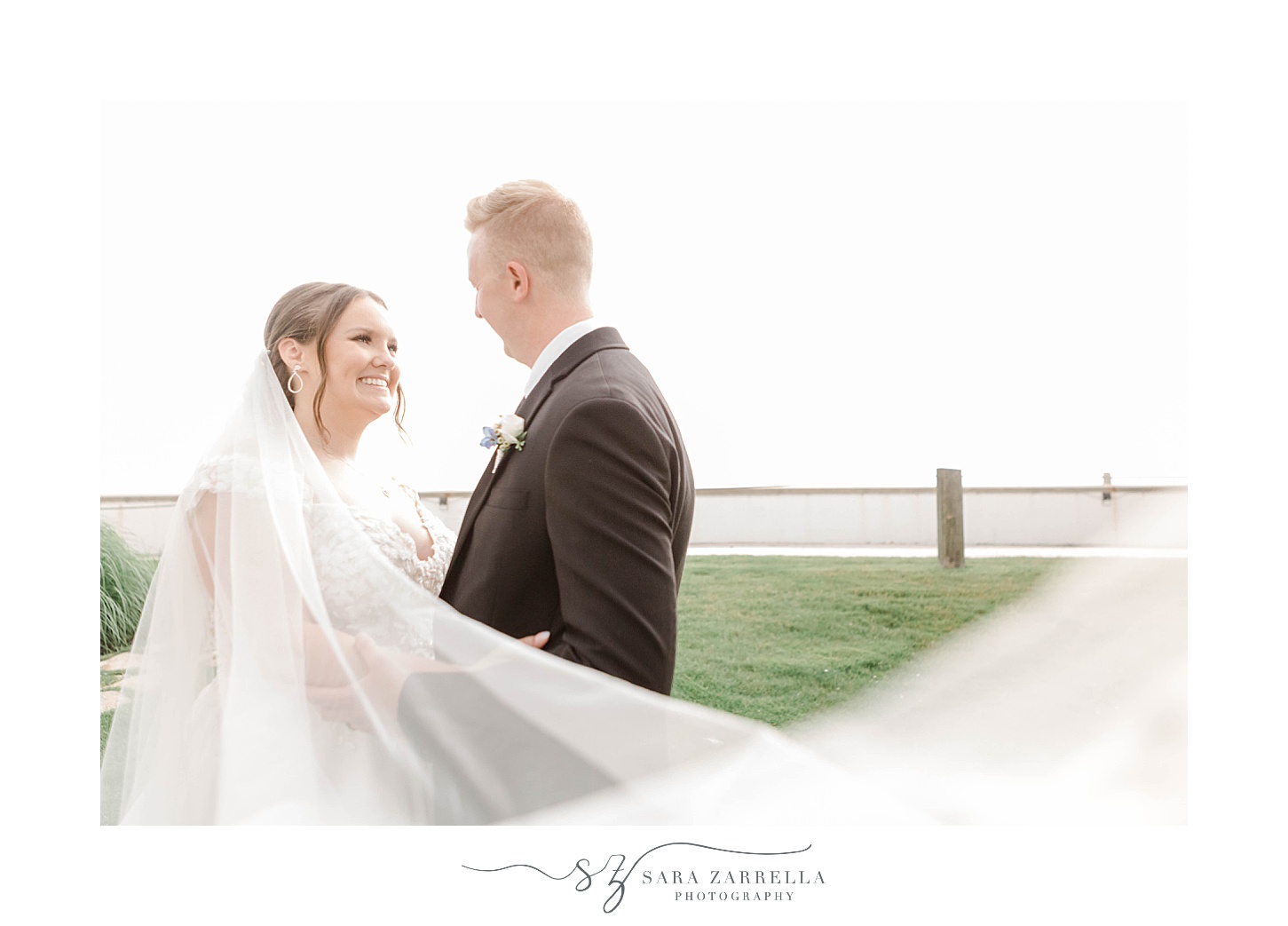 bride and groom hug with veil around them at Newport Harbor Island Resort