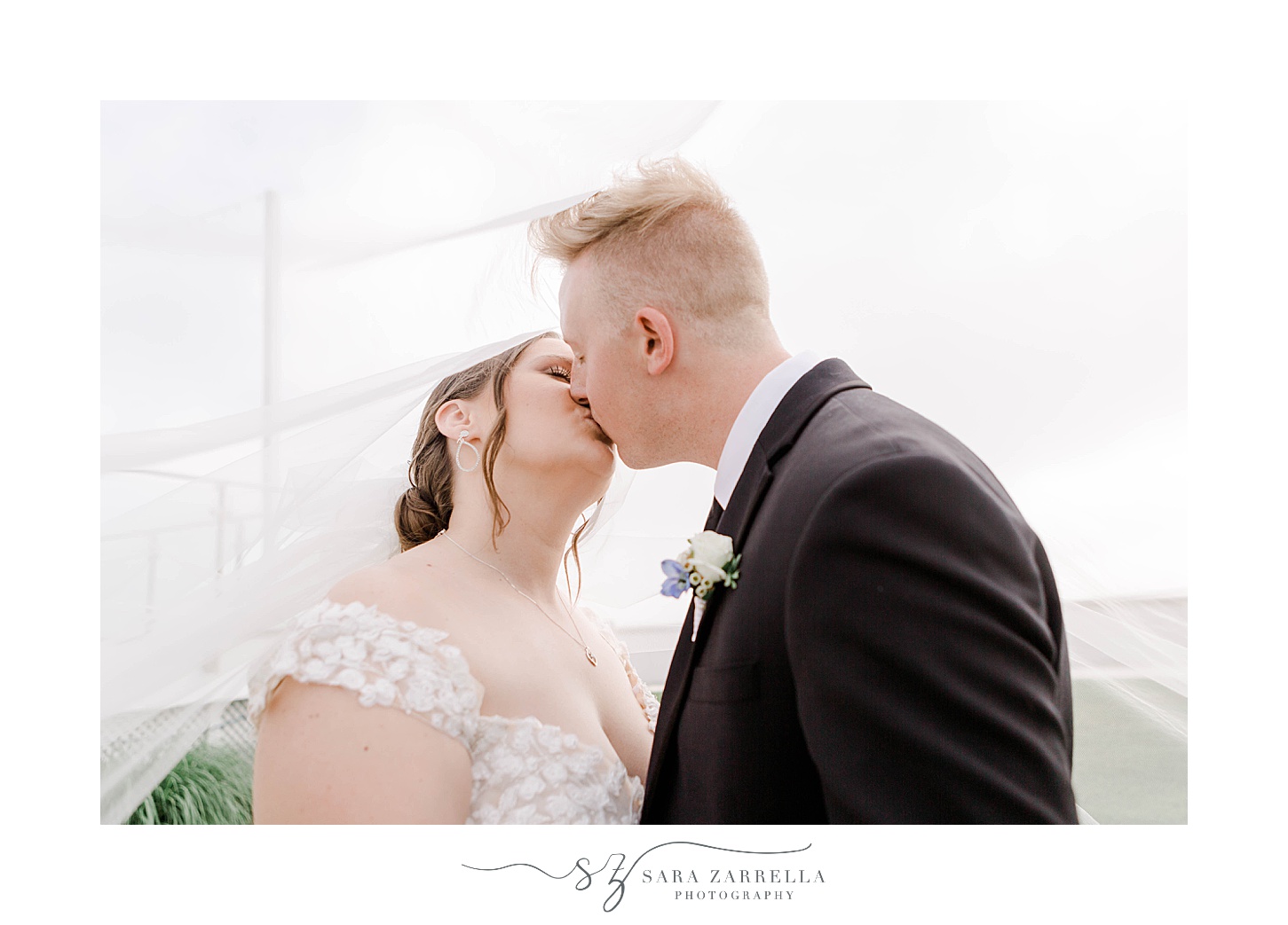 bride and groom kiss in front of the Narragansett Bay