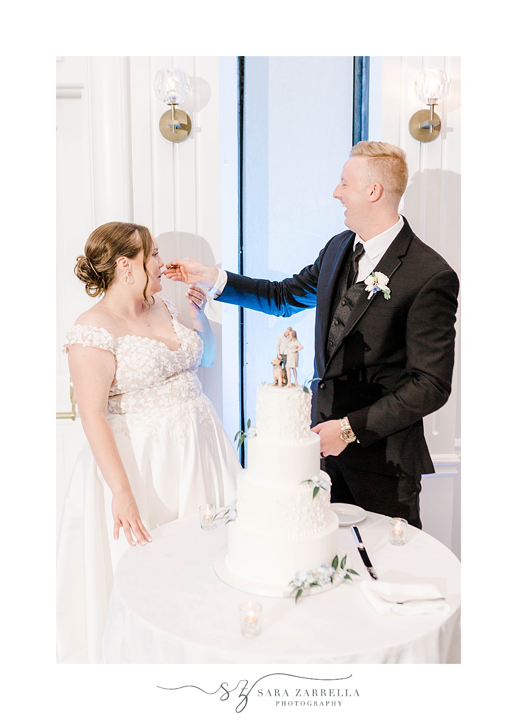 groom feeds bride cake during Newport RI wedding reception