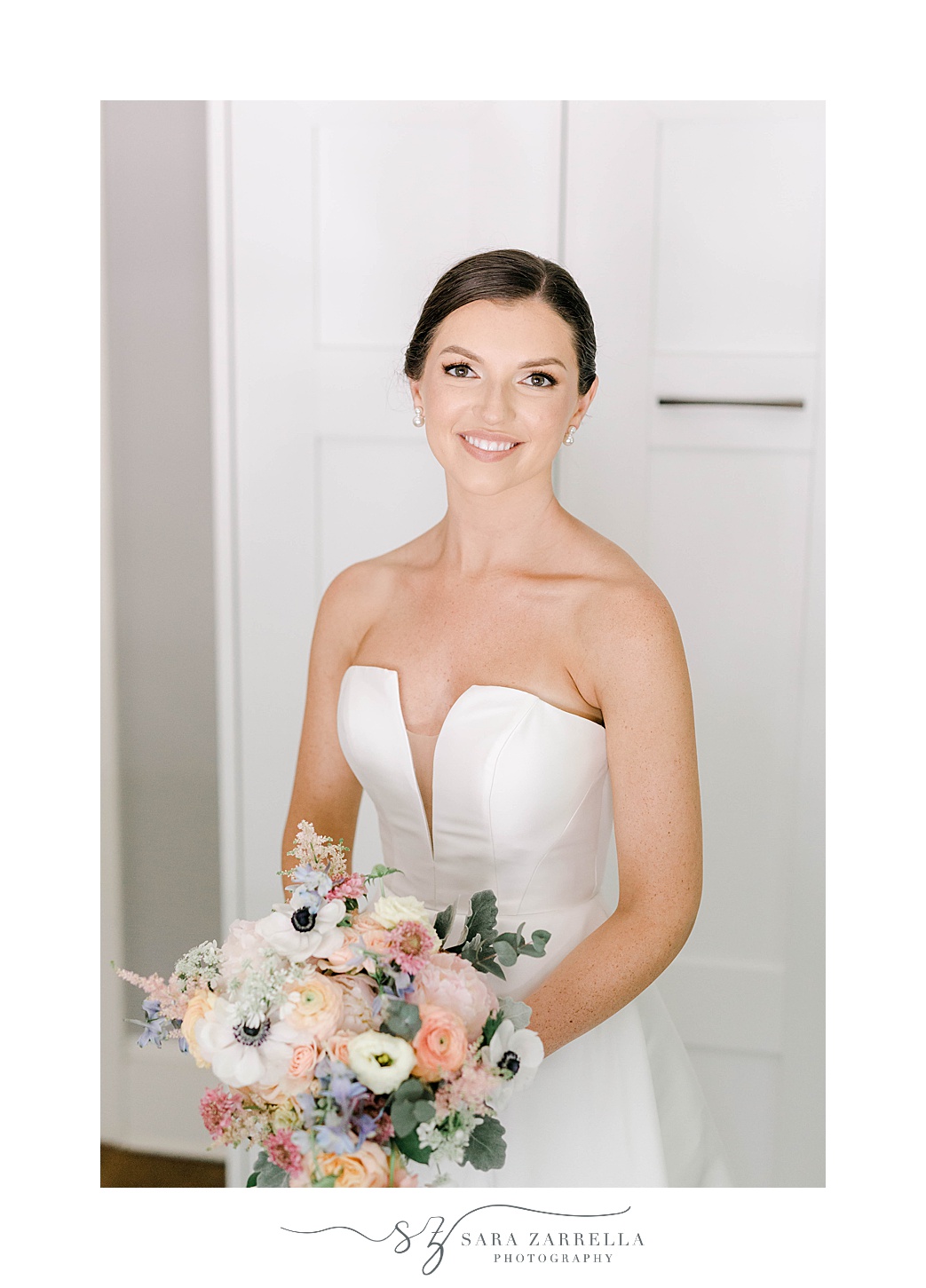 bride holds bouquet of peach, blue, and white flowers