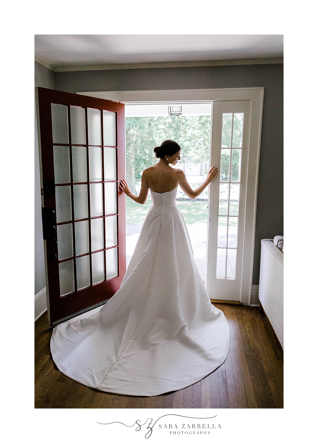 bride poses in door at Regatta Place looking out of frame