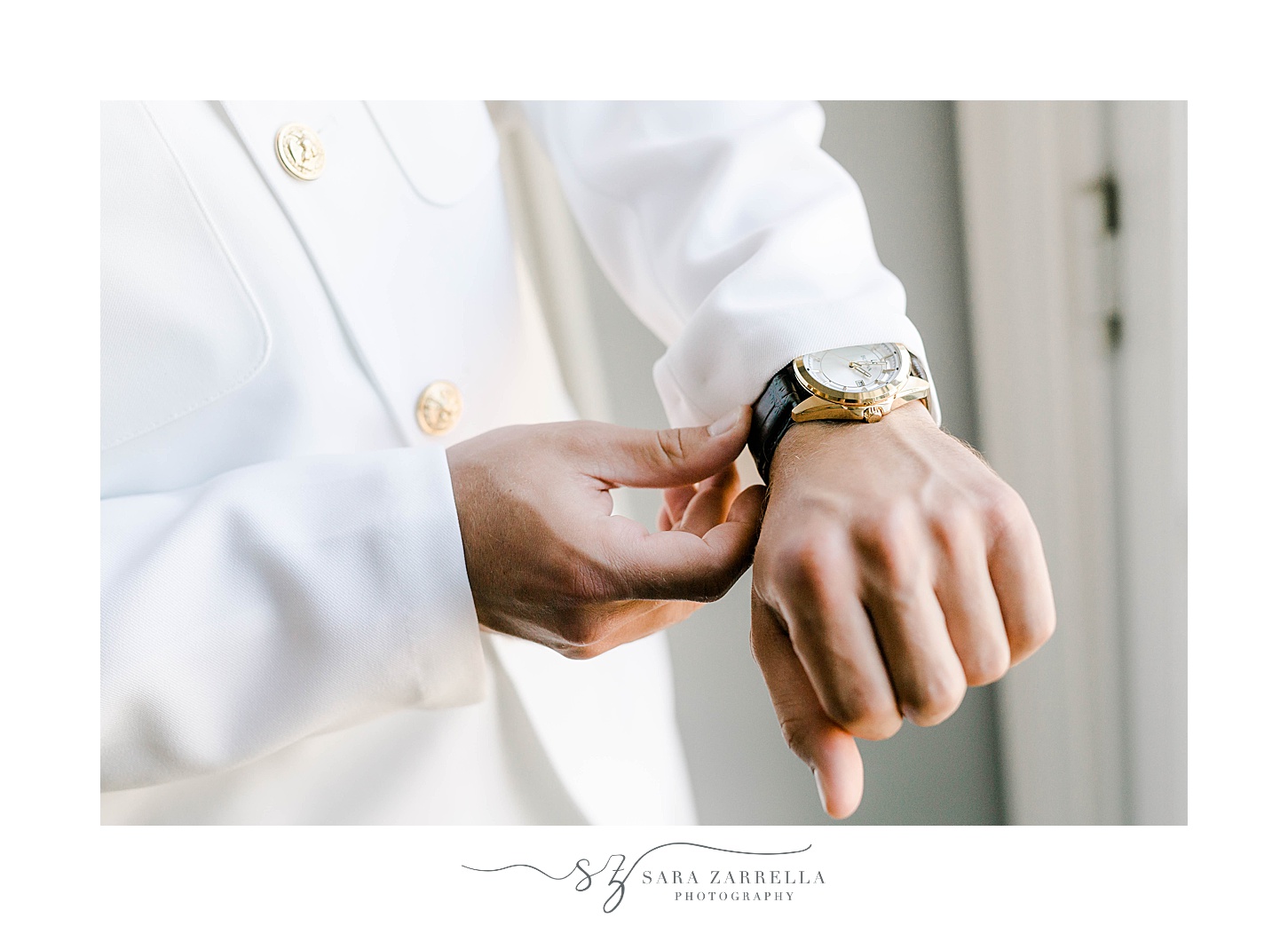 groom adjusts watch in officer whites before Regatta Place wedding