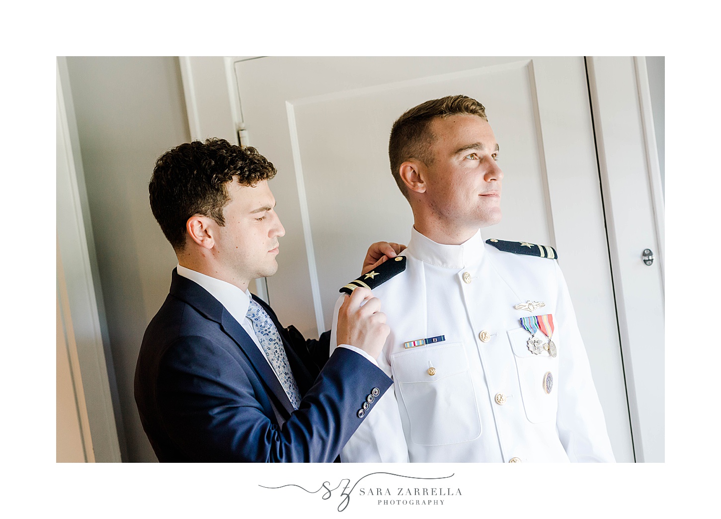 groomsman adjusts bars on top of navy officers uniform