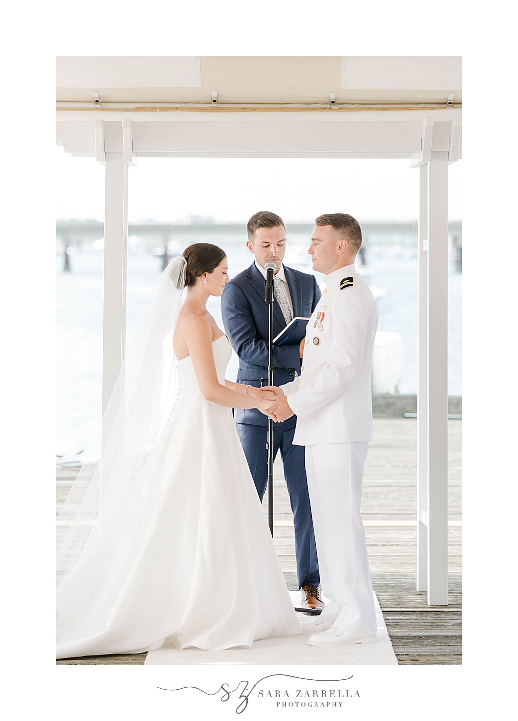 newlyweds hold hands during wedding ceremony at Regatta Place