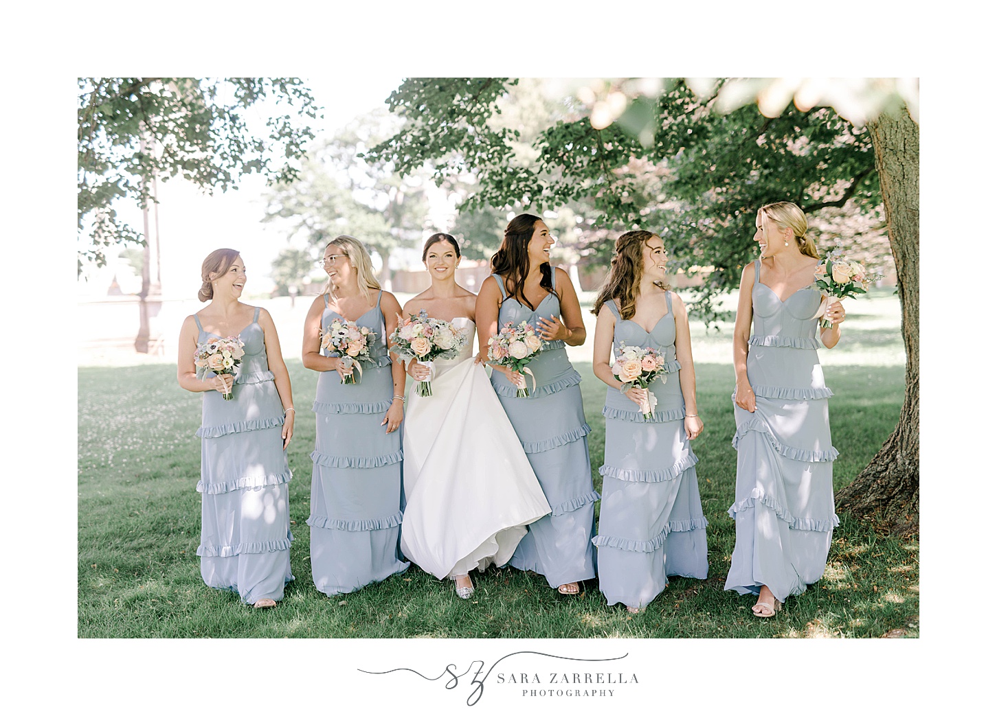 bride poses with bridesmaids in light blue gowns at Ochre Place
