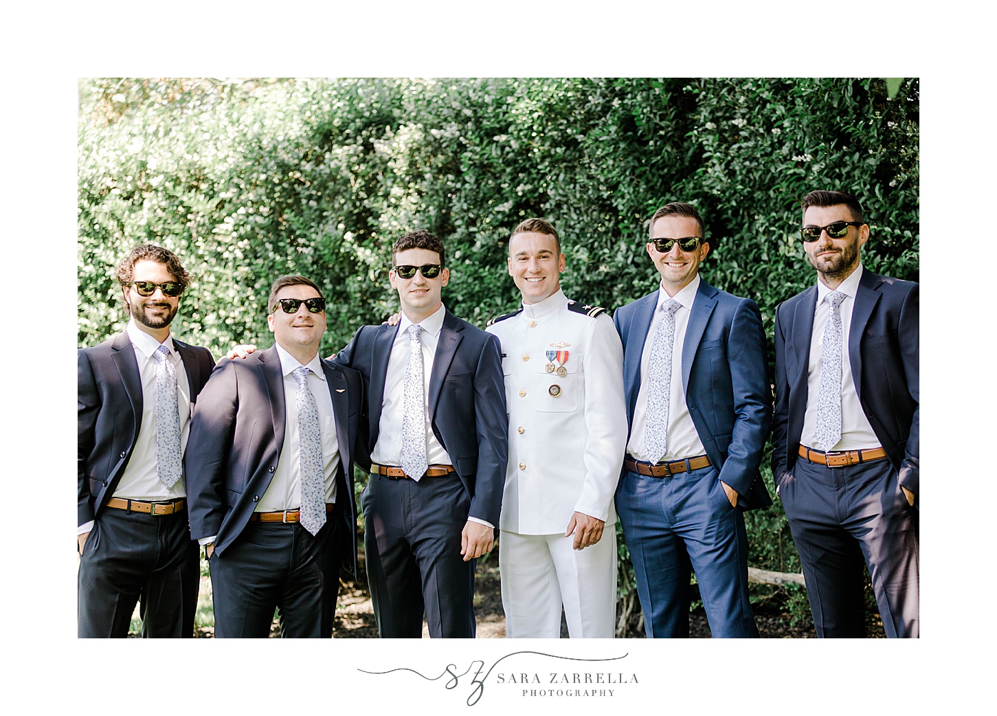 groom in white uniform poses with groomsmen in blue suits at Ochre Place