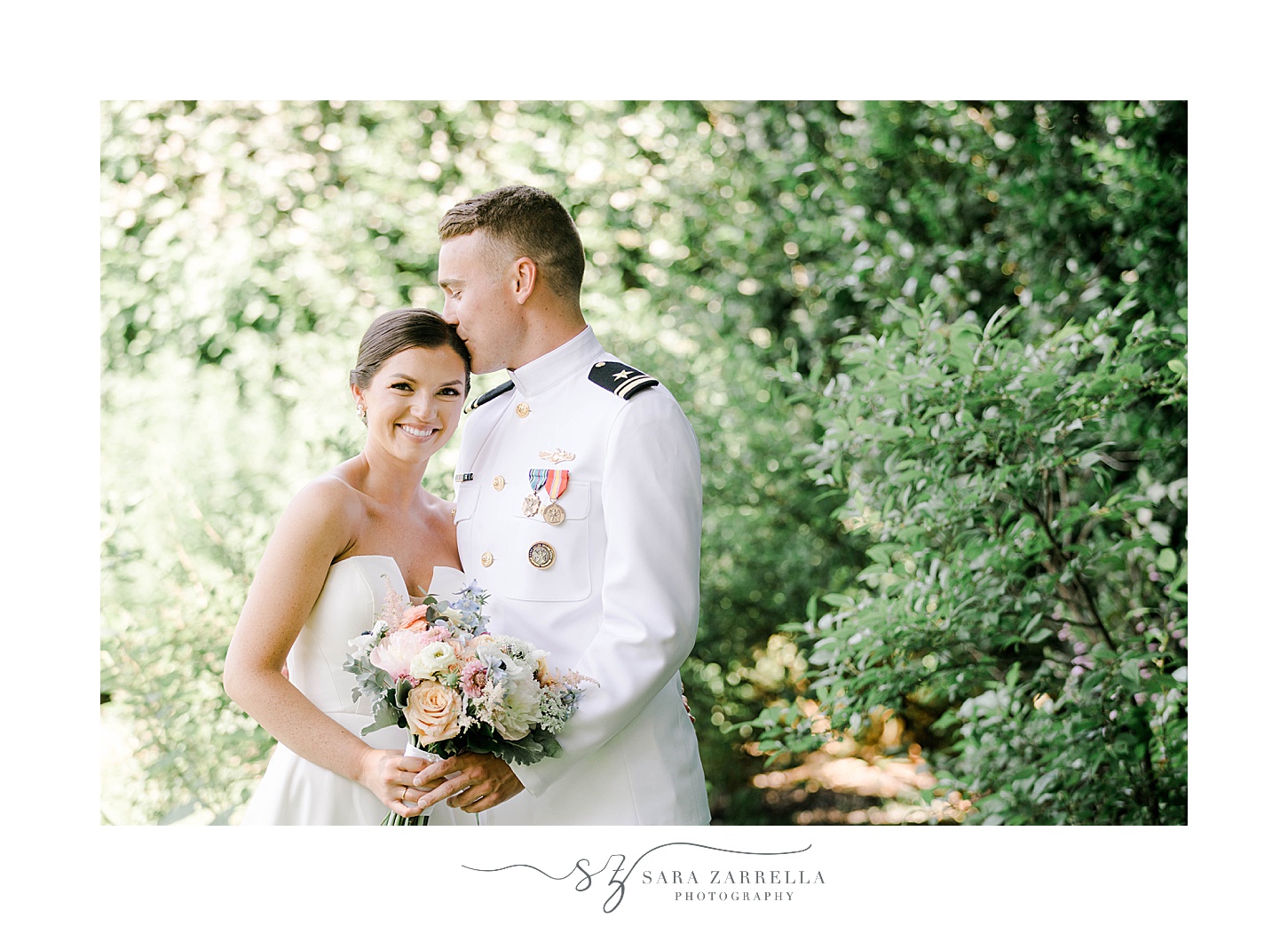 groom in white naval officer's outfit kisses bride's forehead