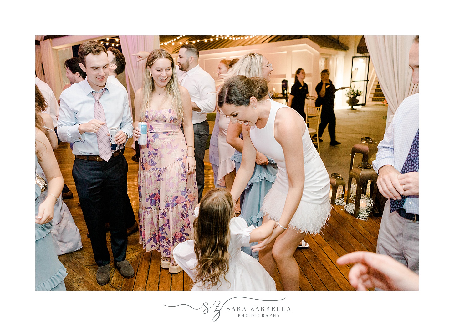 bride dances with flower girl during guests dance during Regatta Place wedding reception