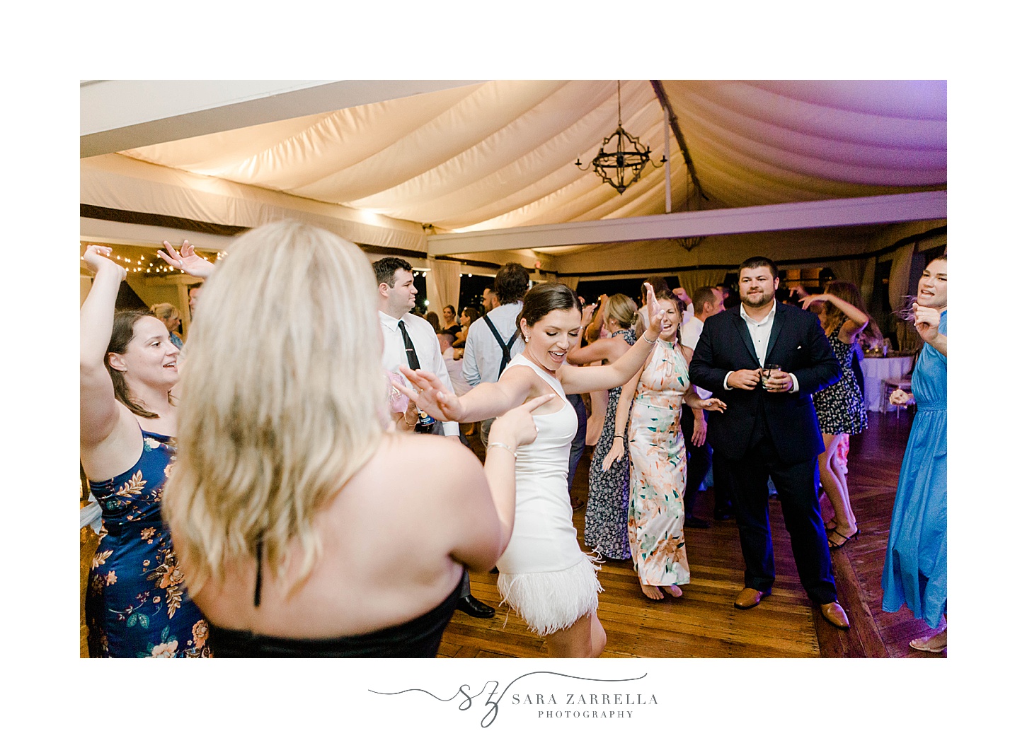 newlyweds dance during guests dance during Regatta Place wedding reception