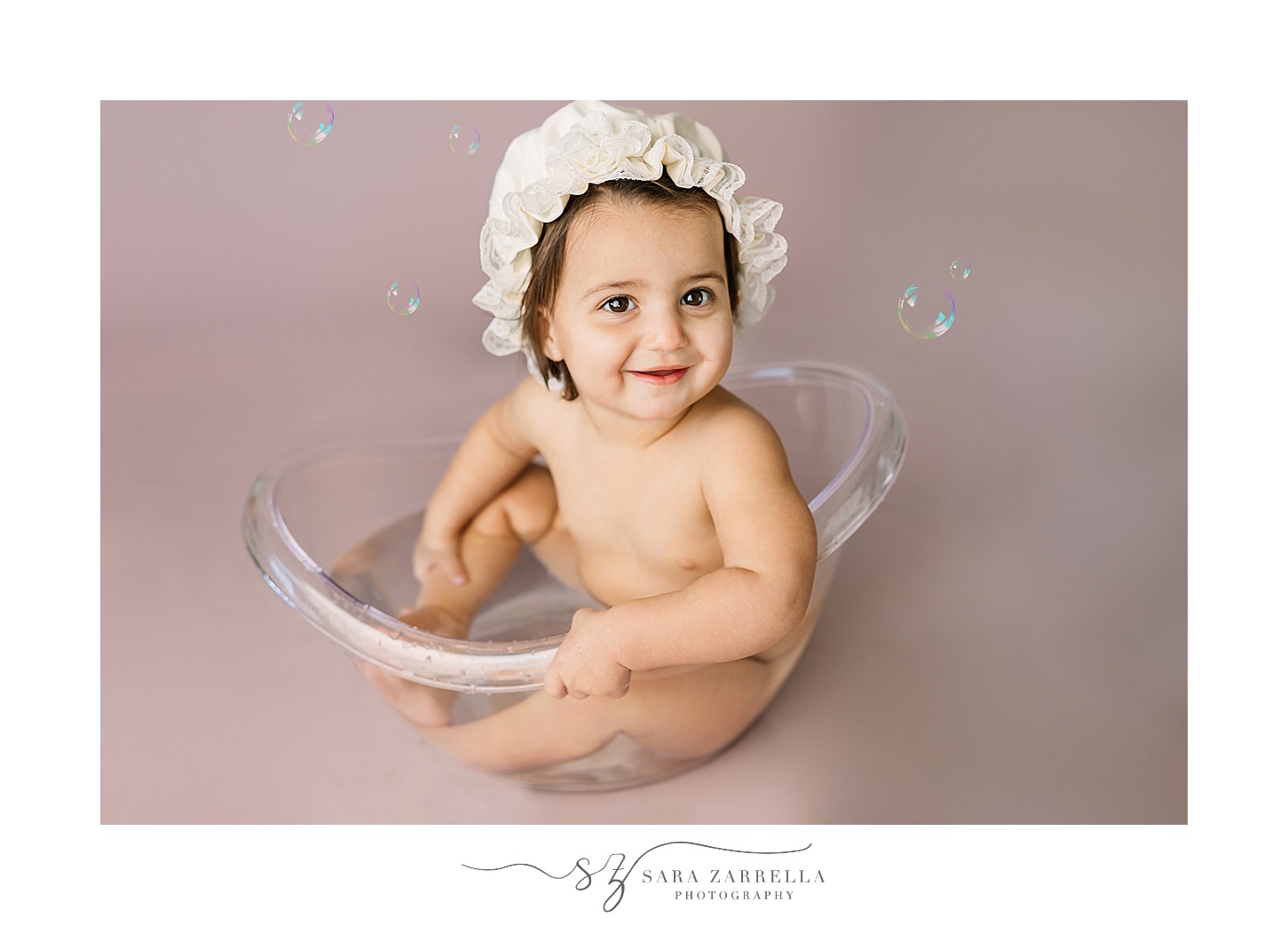 boy sits in tub with white cap during cake smash portraits with Sara Zarrella Photography