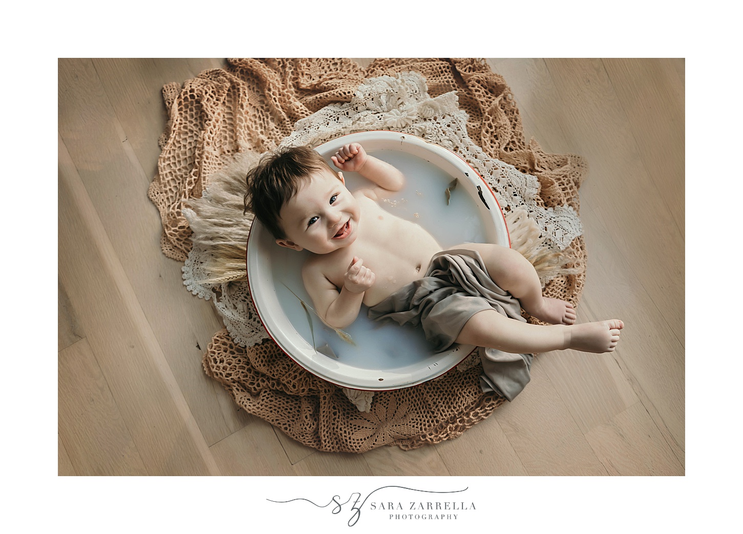 baby lays in tub during cake smash portraits with Sara Zarrella Photography