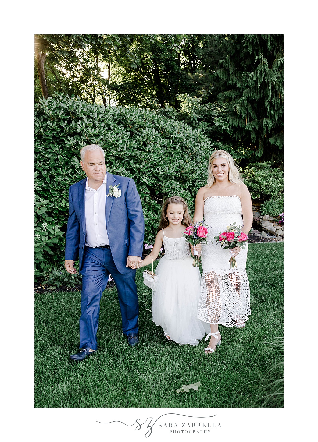 newlyweds walk with flower girl in gardens of Kirkbrae Country Club