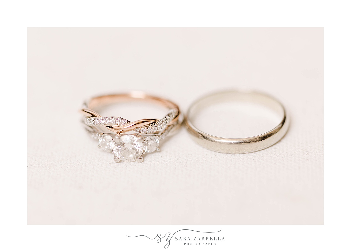 gold wedding bands lay together on ivory backdrop 