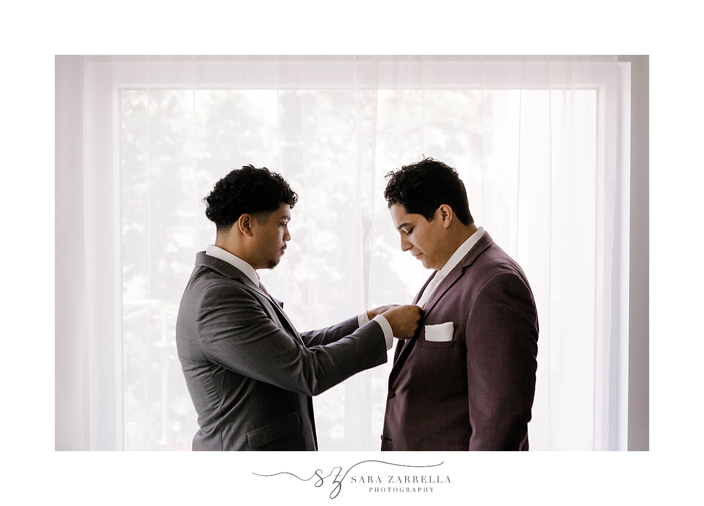 groomsman adjusts tie and pocket square for groom in Newport RI