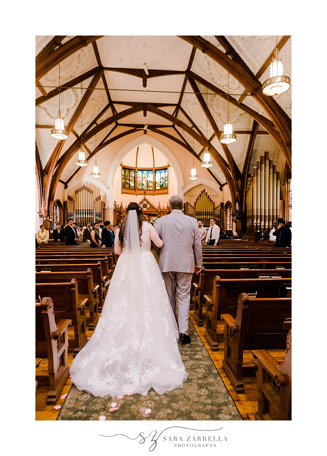 bride walks down aisle with father before traditional church wedding in Newport RI