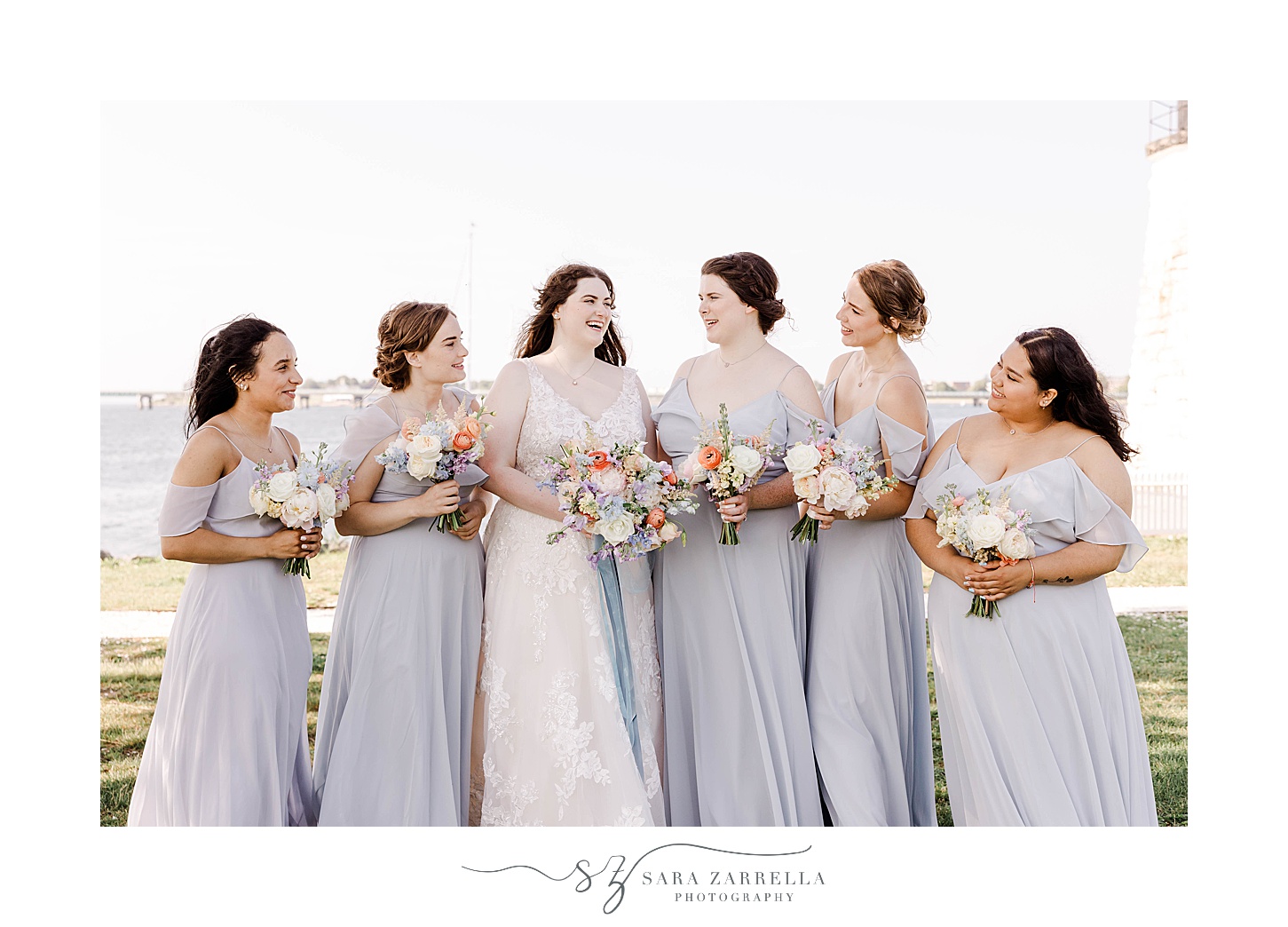 bride poses with bridesmaids in light blue gowns at Newport Harbor Island Resort 