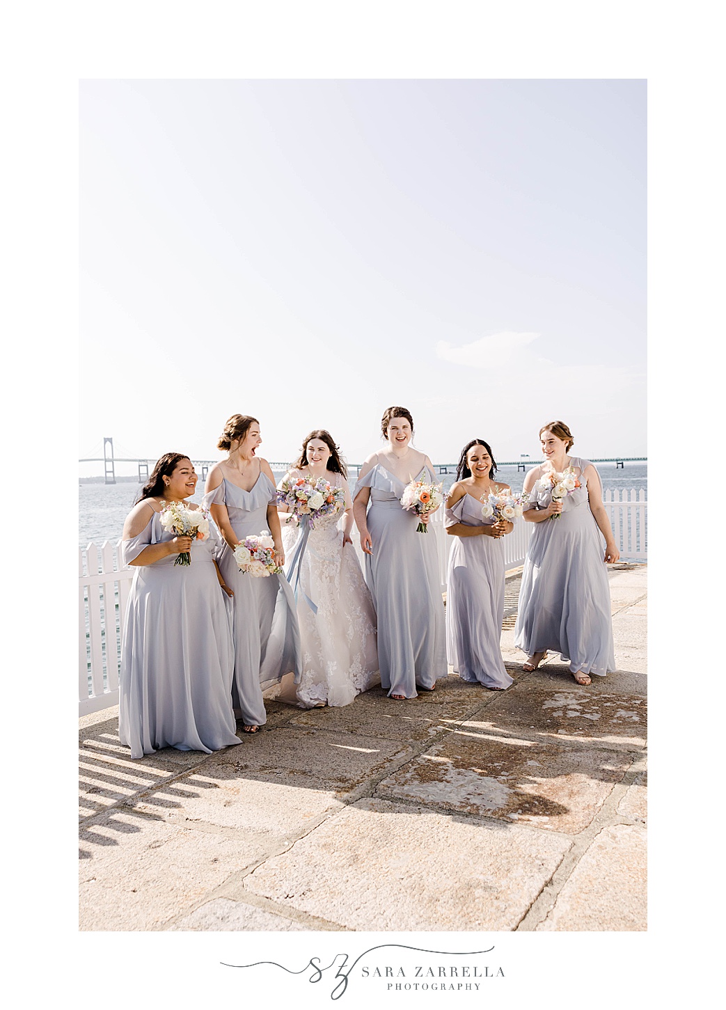bride walks with bridesmaids in blue gowns at Newport Harbor Island Resort 