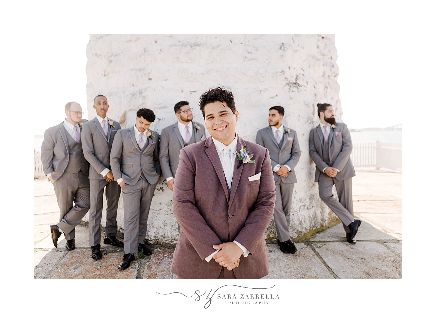 groom stands with groomsmen in light purple suit at Newport Harbor Island Resort 