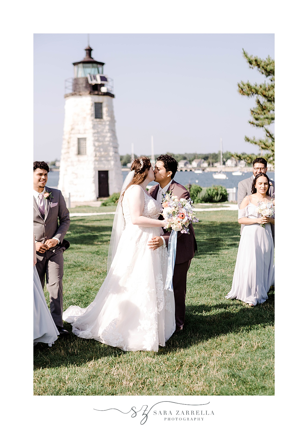newlyweds kiss surrounded by wedding party at Newport Harbor Island Resort 