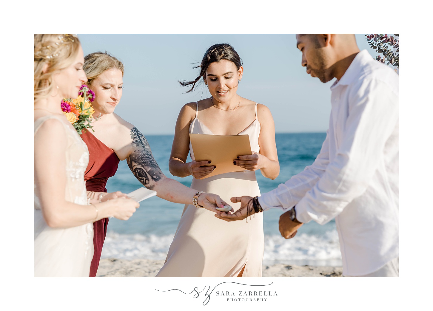 bridesmaid hands rings to couple during Charlestown Beach wedding ceremony
