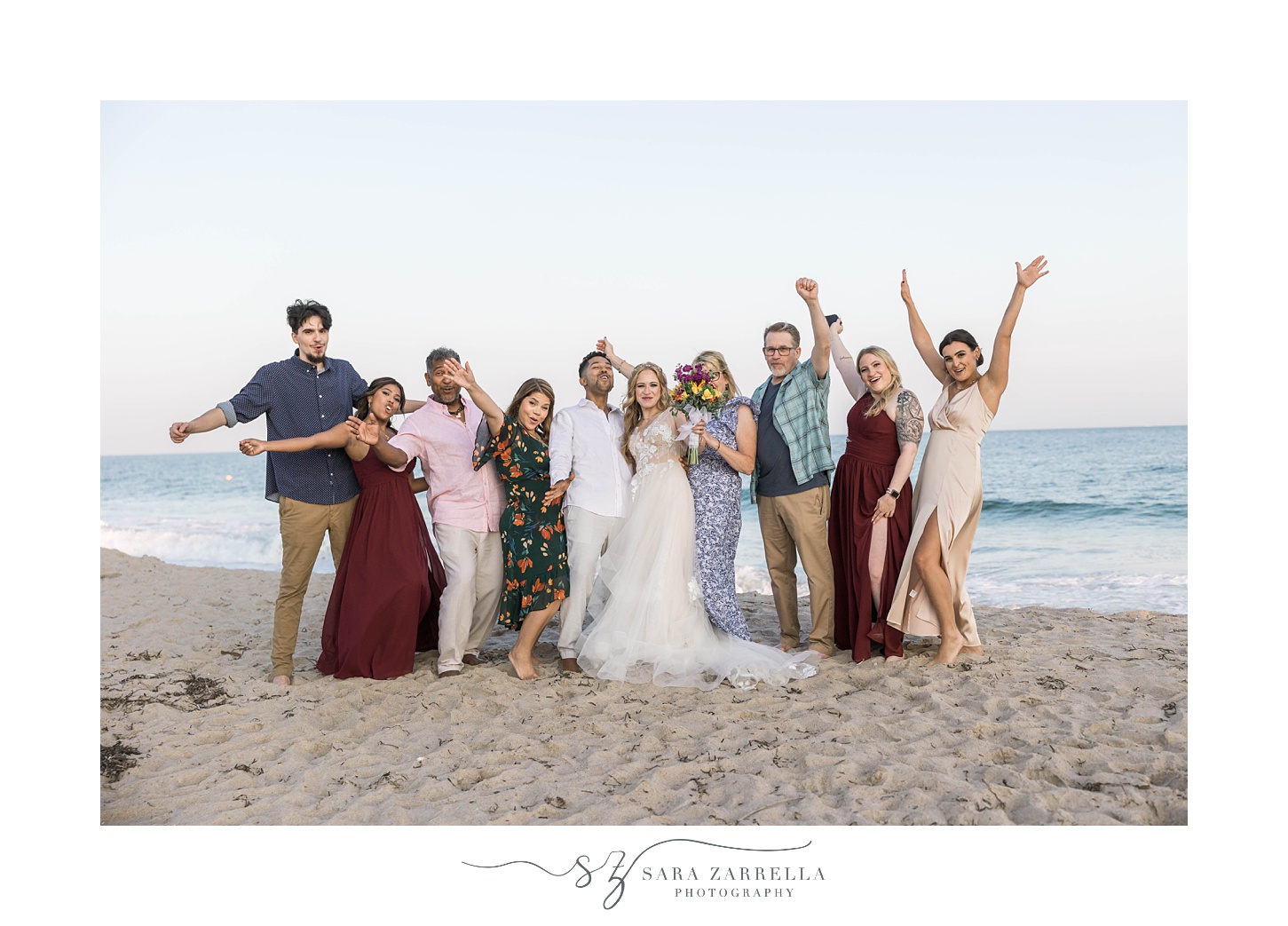 newlyweds cheer with family on beach after intimate wedding 