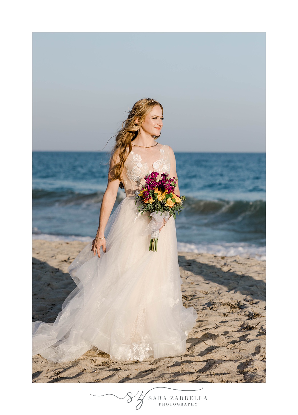 bride stands on sand looking at beach during Charlestown Beach wedding 