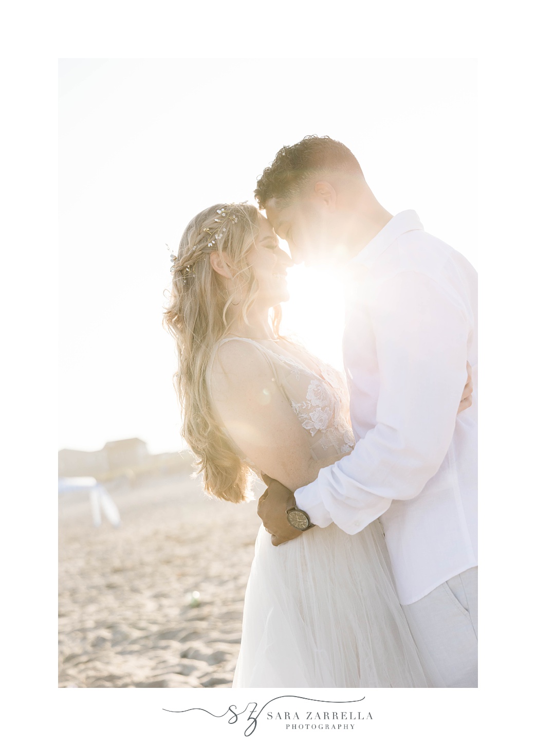 bride and groom hug with sun coming between them on Charlestown Beach