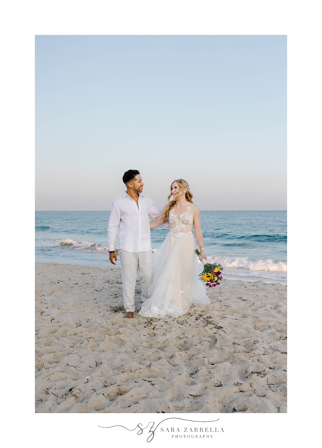 bride and groom hold hands walking on Charlestown Beach