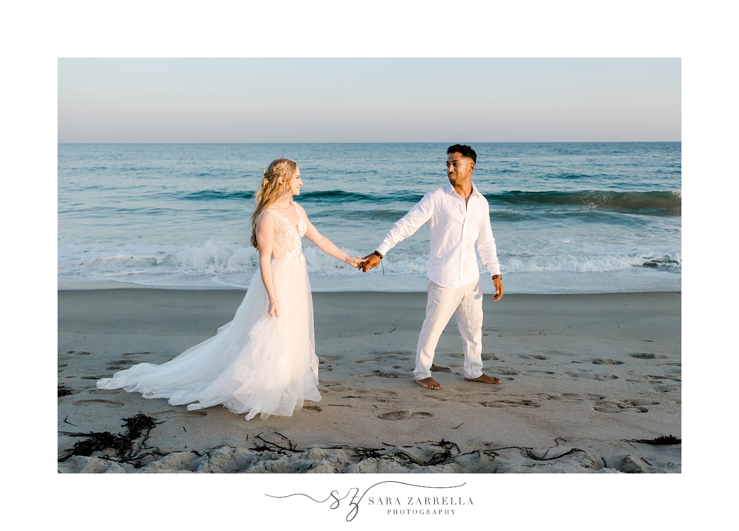 groom in white linen shirt leads bride across sand during Charlestown Beach wedding photos 