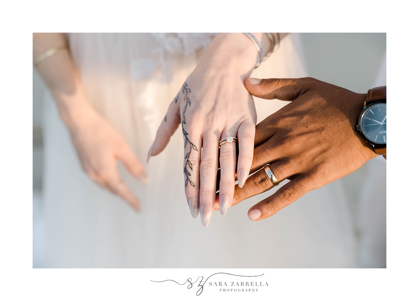white woman and tan man hold up hands showing off rings