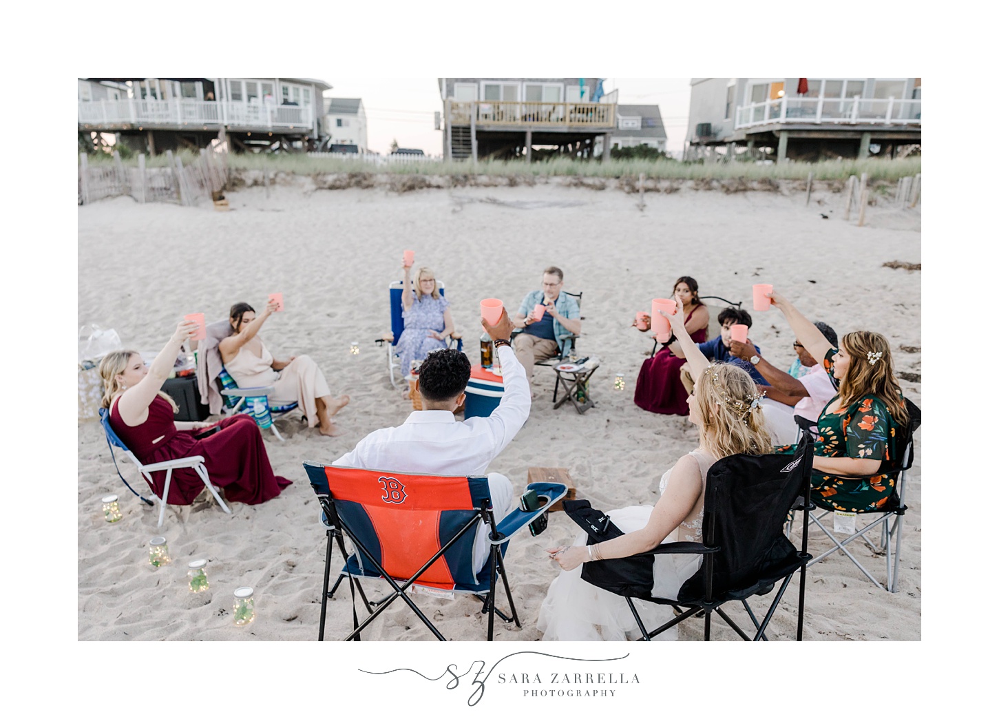 guests sit in circle talking during beach wedding reception in Rhode Island