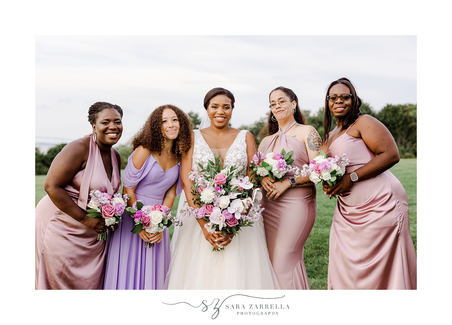 bride hugs bridesmaids with pink and purple dresses at OceanCliff Hotel