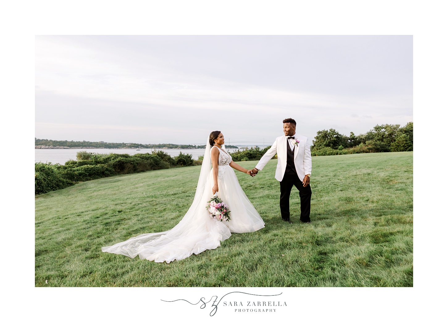 groom leads bride across lawn at OceanCliff Hotel