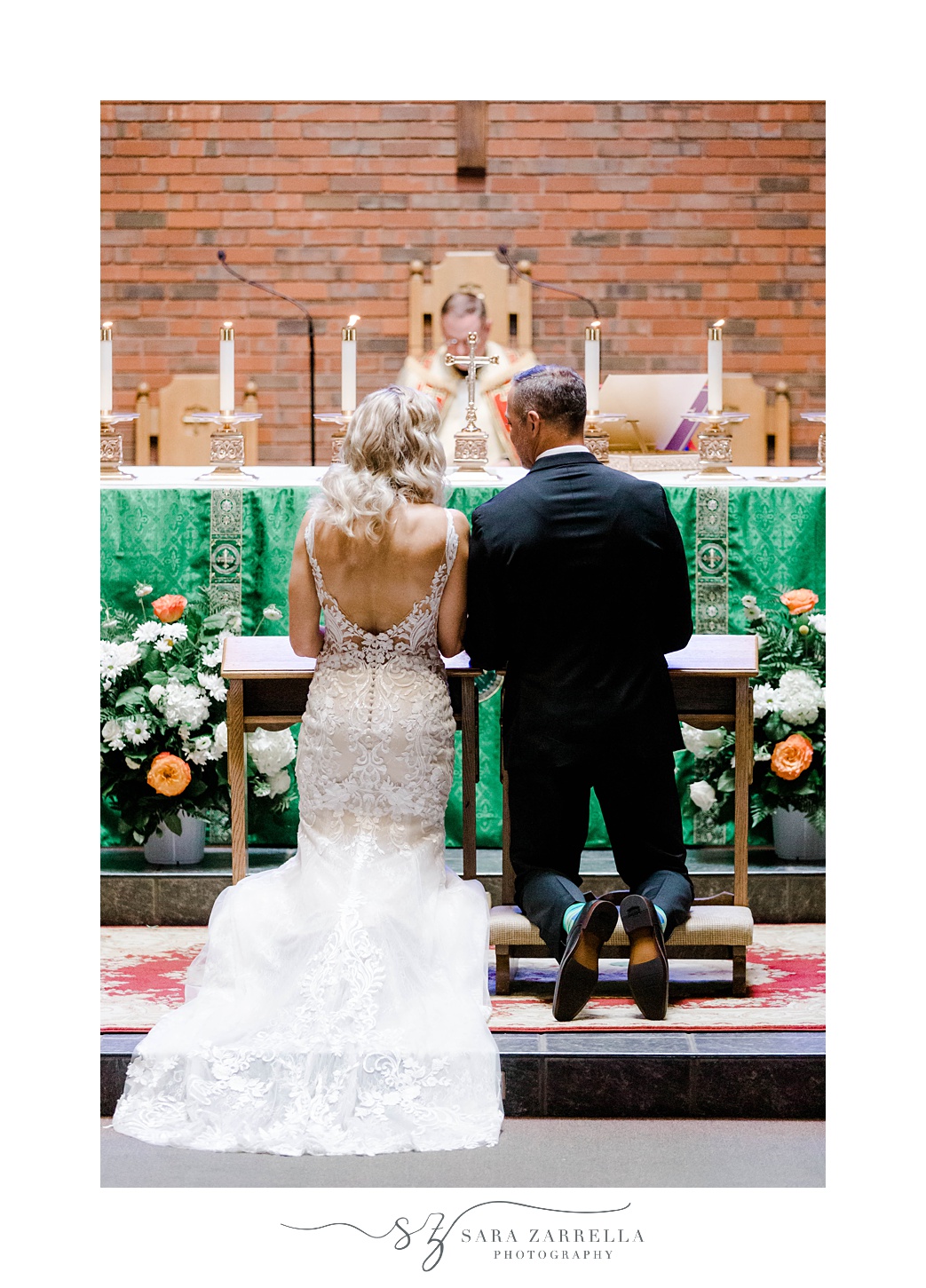 newlyweds kneel at alter during traditional church wedding in Sutton MA