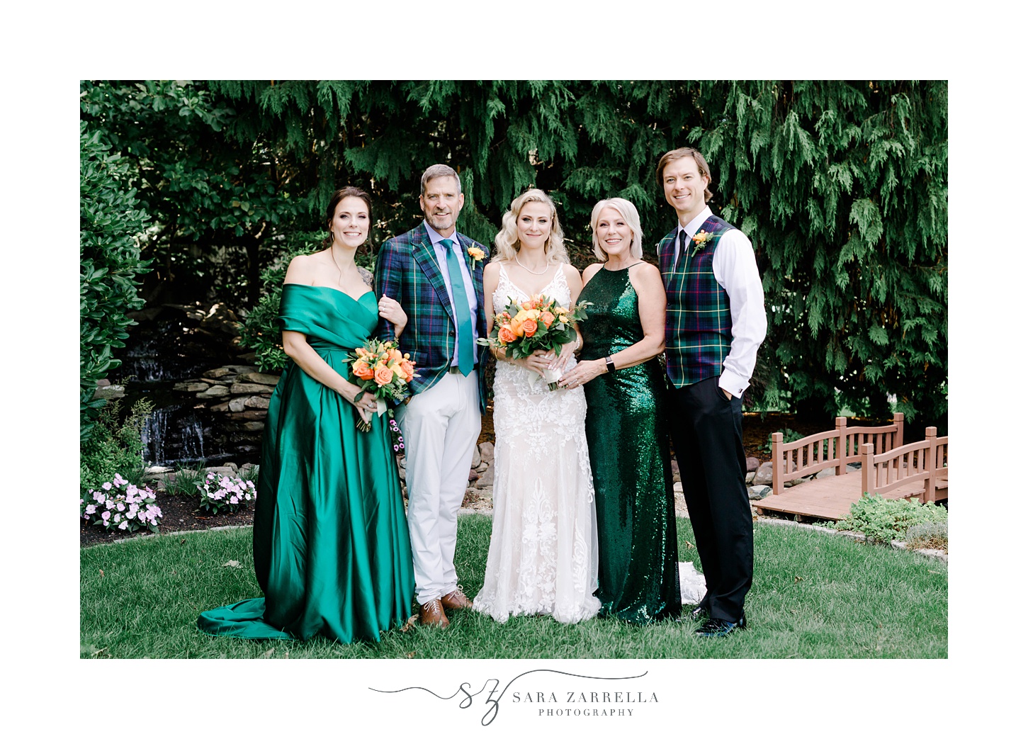 bride and groom pose with wedding party in emerald green dresses and plaid vests 