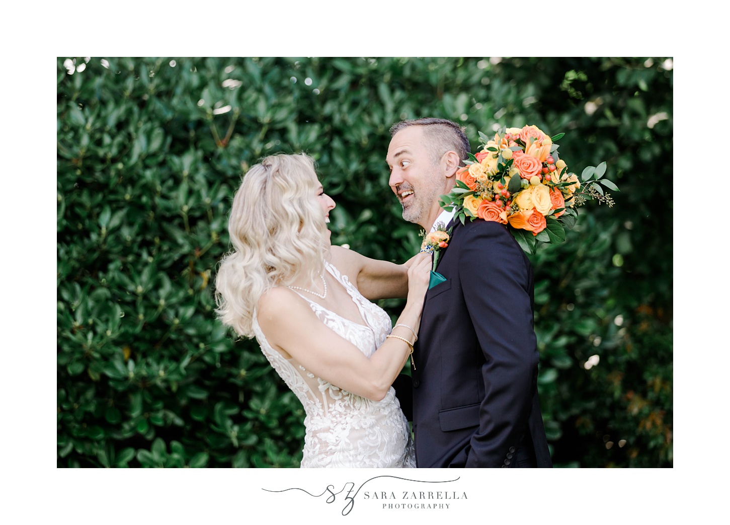 bride and groom smile at each other with bride holding bright yellow and orange flower bouquet 