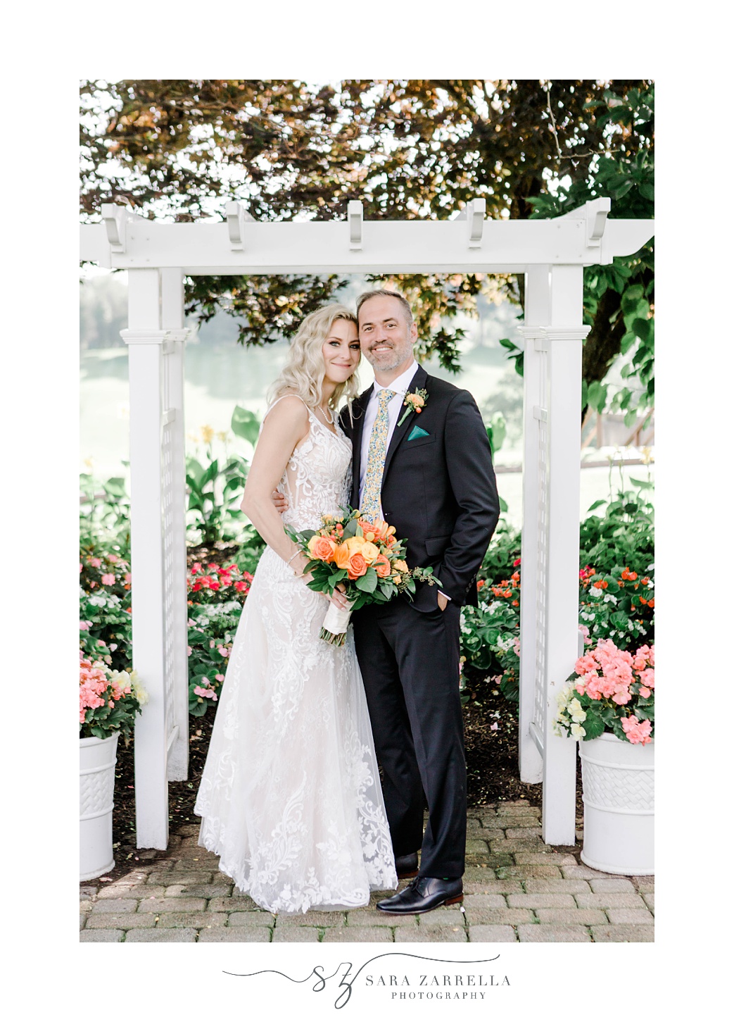 bride and groom hug under white arbor on patio at Pleasant Valley Country Club