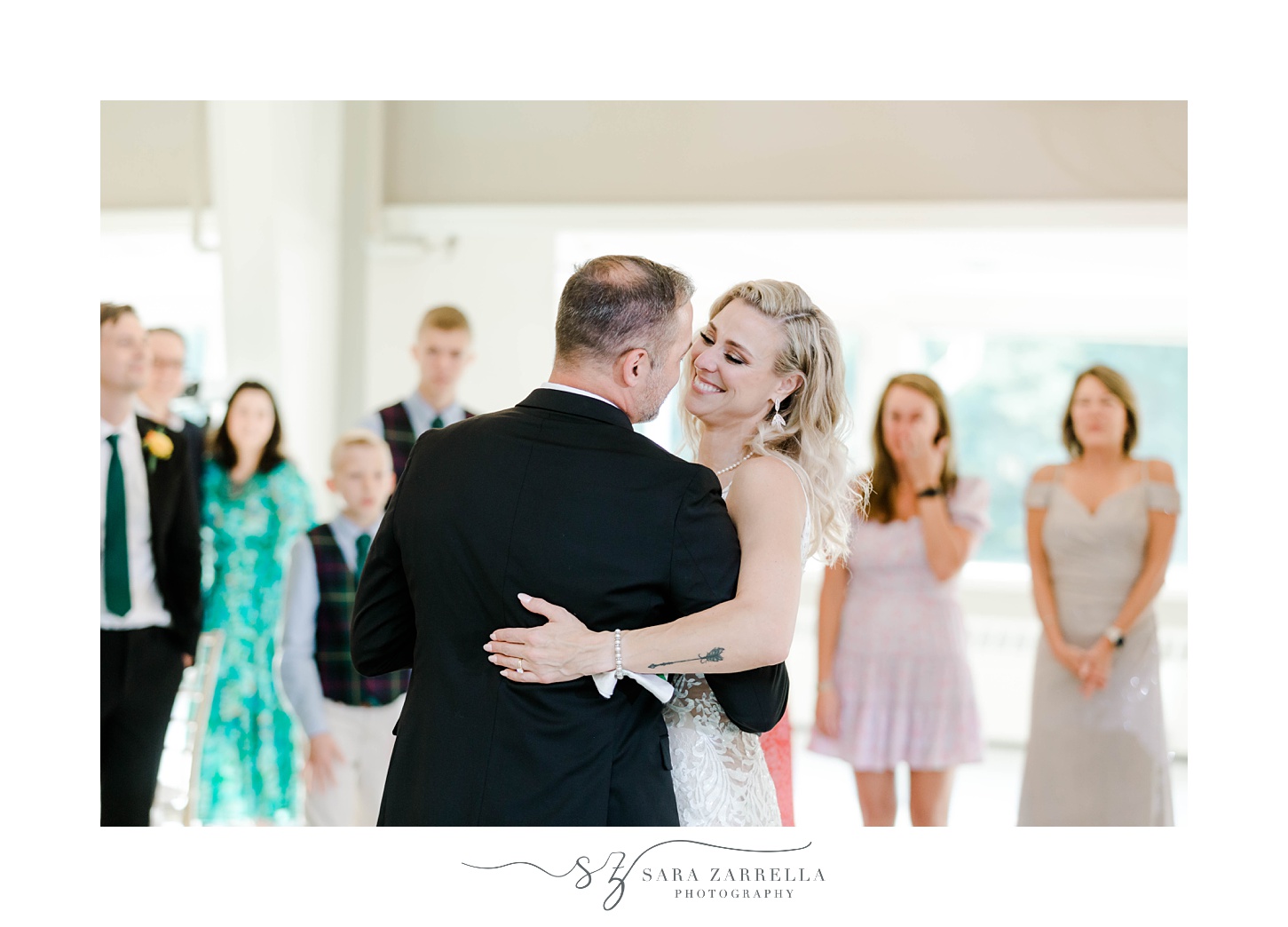 bride smiles at groom during first dance during Sutton MA wedding reception