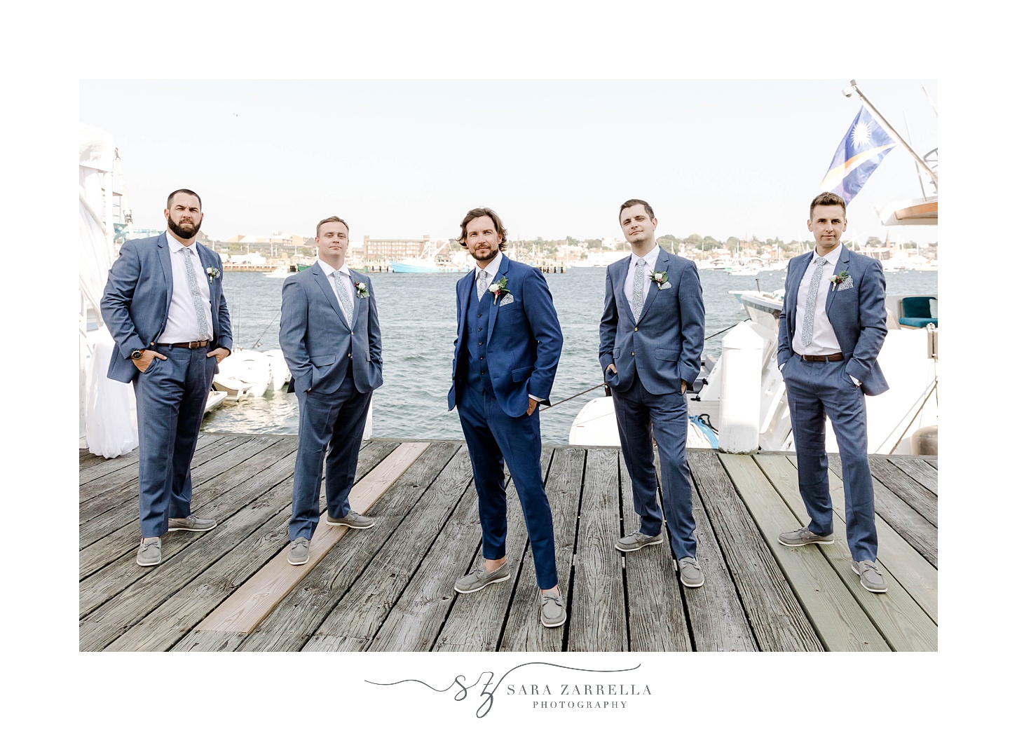 groom and groomsmen stand on dock at Regatta Place