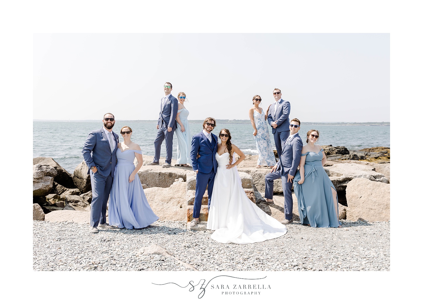 newlyweds stand on rocks with bridesmaids and groomsmen in Newport RI