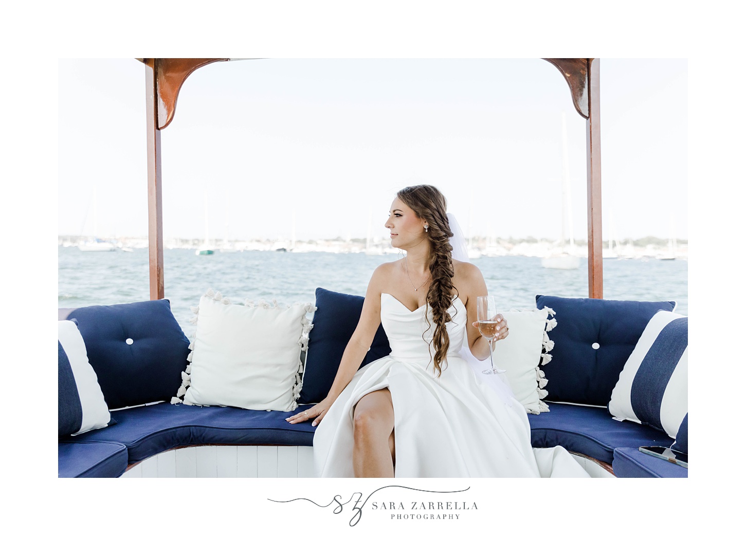 bride sits on boat during Newport RI wedding photos 