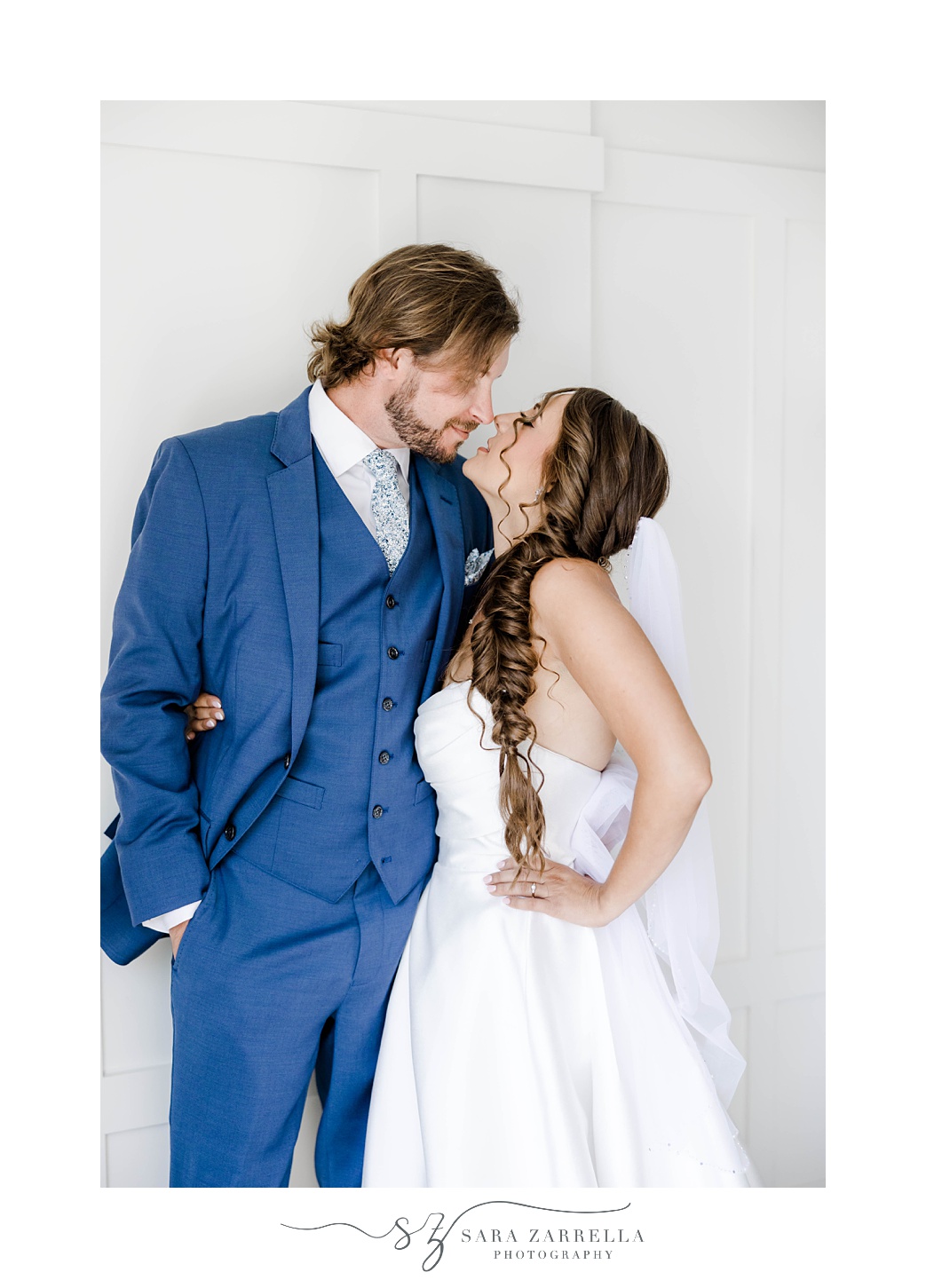 newlyweds kiss by white walls in Regatta Place