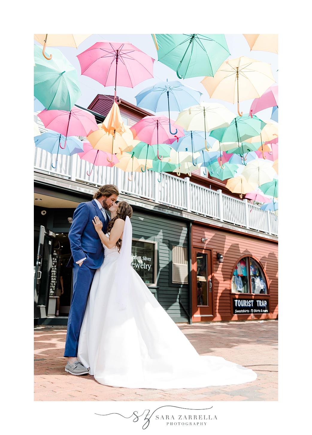 newlyweds hug under umbrellas in Market Square 