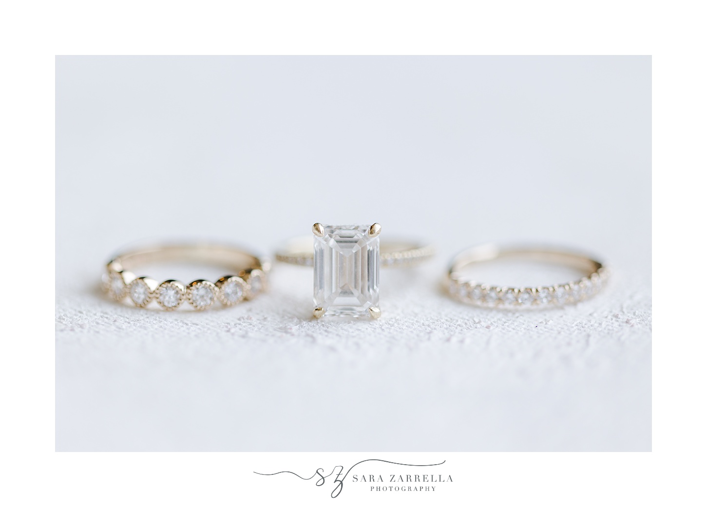 silver and diamond wedding rings rest on marble paper